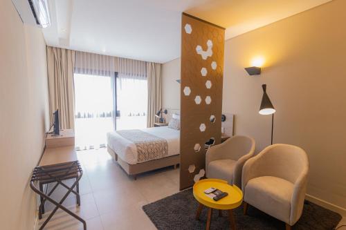 マル・デル・プラタにあるHotel Treinta-Seisのベッドと椅子付きのホテルルーム