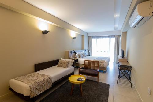 a hotel room with two beds and a table at Hotel Treinta-Seis in Mar del Plata
