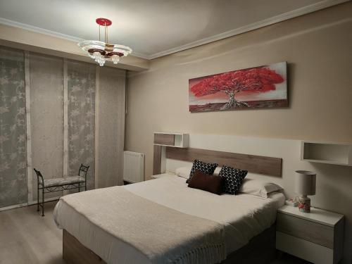 1 dormitorio con 1 cama y un árbol rojo en la pared en BlueMedina Lugones, en Lugones