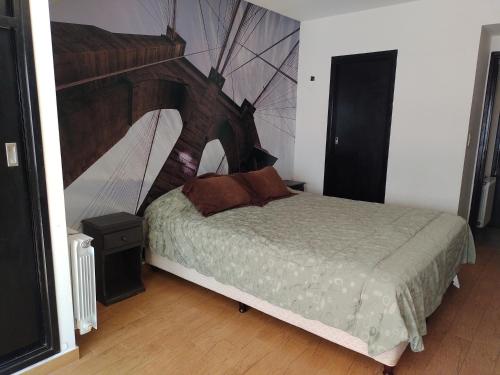 een slaapkamer met een groot bed met een houten hoofdeinde bij Depto 2 amb- Punta Mogotes- ideal para altos in Mar del Plata