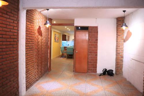 a black cat sitting on the floor in a hallway at Corazón de Atlixco in Atlixco