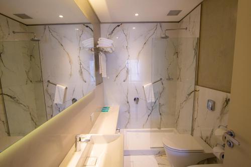 a bathroom with a sink and a shower and a toilet at Hotel Treinta-Seis in Mar del Plata