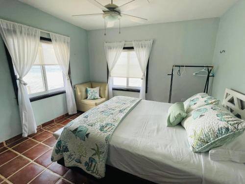1 dormitorio con 1 cama y 2 ventanas en Gorgeous Oceanfront Villa Solana with Pool and Direct Beach Access, en Santa Clara