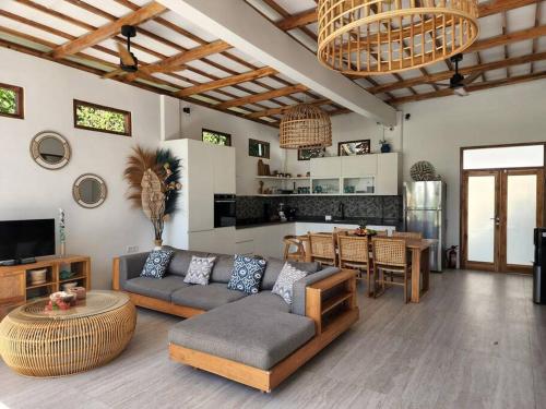 ein Wohnzimmer mit einem Sofa und einem Tisch in der Unterkunft Rumah Tara Modern 3 bedroom pool and garden villa in Gili Air in Gili Air