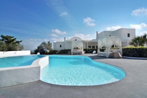 a swimming pool in front of a house at Villa Irene Santorini in Vourvoúlos