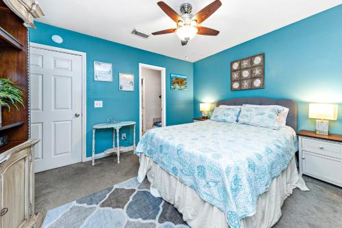 a blue bedroom with a bed and a ceiling fan at Cozy budget friendly condo close to the beach in Gulf Shores