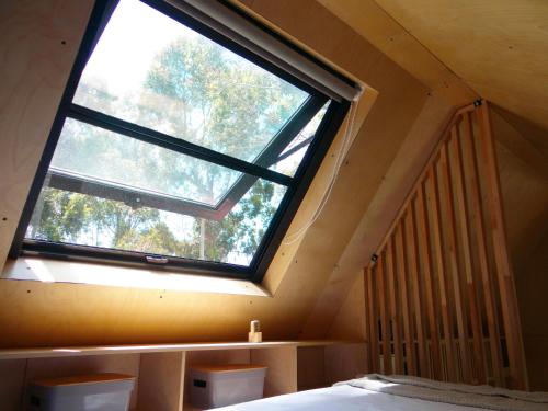 a bedroom with a large window in a attic at Viví la experiencia de hospedarte en una tiny in La Pedrera