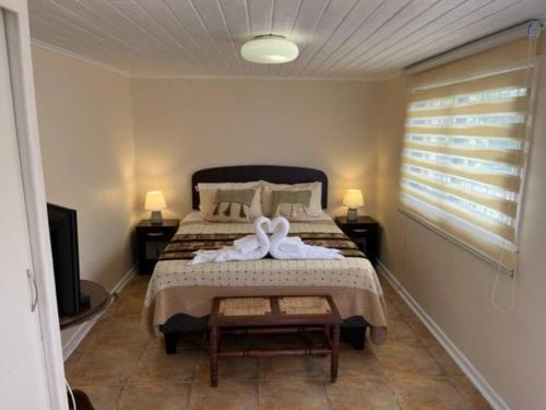Un dormitorio con una cama con una toalla blanca. en Cabaña para 2 en ConCon, en Concón