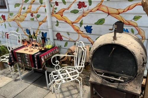 un patio con horno de pizza, mesa y sillas en Cabaña para 2 en ConCon, en Concón