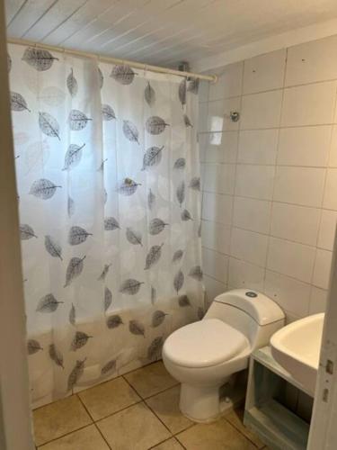 a bathroom with a toilet and a shower curtain at Cabaña para 2 en ConCon in Concón