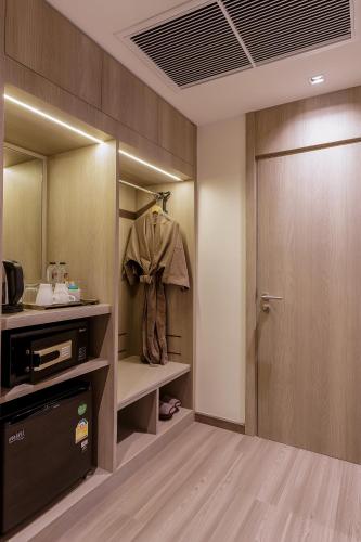 a room with a closet with a robe and a door at Fifth Pattaya Jomtien By Shiwalai Int in Jomtien Beach