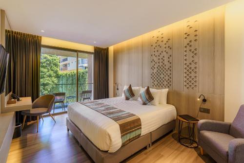 a bedroom with a bed and a couch and a chair at Fifth Pattaya Jomtien By Shiwalai Int in Jomtien Beach