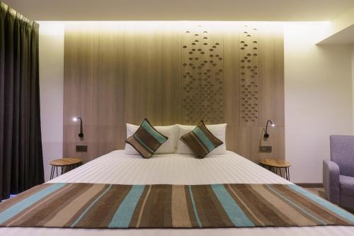 a bedroom with a large bed with two pillows at Fifth Pattaya Jomtien By Shiwalai Int in Jomtien Beach