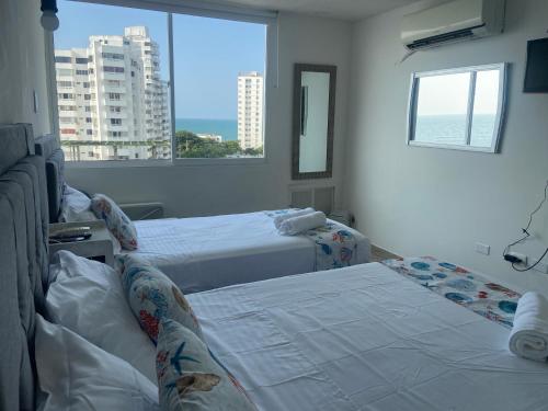 a hotel room with two beds and a window at FRAGATA STYLE 2 in Cartagena de Indias