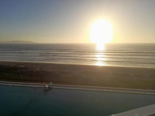 a sunset over the ocean with a boat in the water at laguna del mar, la serena in La Serena