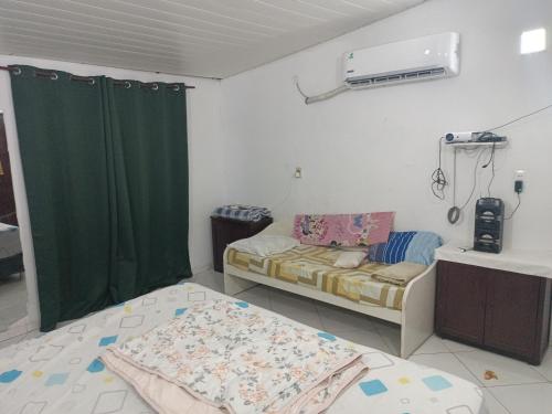 Habitación con 2 camas y cortina verde en Departamento LEDESMA 2 piso, en Asunción