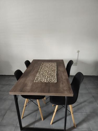 una mesa de madera con cuatro sillas negras alrededor en JBJusto en Villa Carlos Paz