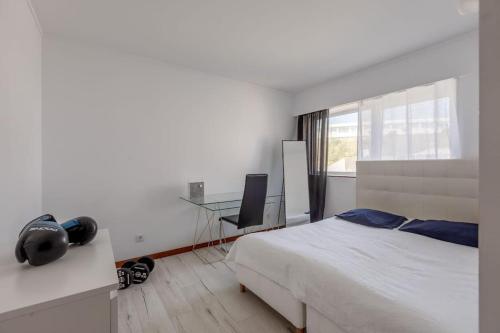 Spacious 3-bedroom condo in Lisbon في لشبونة: غرفة نوم مع سرير ومكتب مع جهاز كمبيوتر