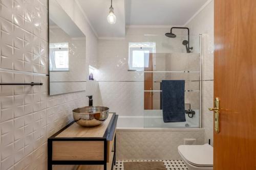 Spacious 3-bedroom condo in Lisbon في لشبونة: حمام مع وعاء على طاولة بجوار حوض الاستحمام