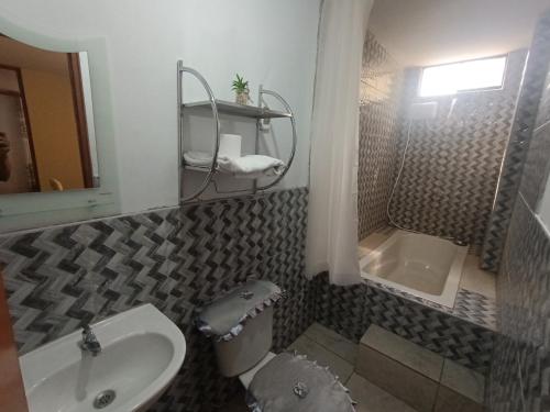 a bathroom with a sink and a toilet and a tub at LUANA’S HOUSE in Ica