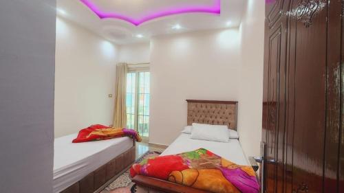 アレクサンドリアにあるشقة فندقية مكيفة ميامي ع البحر مباشرةًの紫色の天井のベッドルーム1室(ベッド2台付)