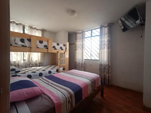 a bedroom with two beds and a window at LUANA’S HOUSE in Ica