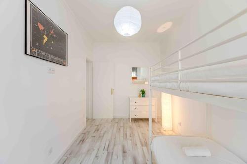 Habitación blanca con litera y dormitorio en Lovely 3-bedroom condo w/ free parking on premises en Queluz