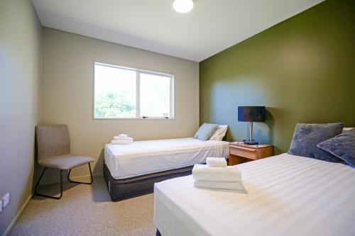 a hotel room with two beds and a window at Parehua Resort in Martinborough 