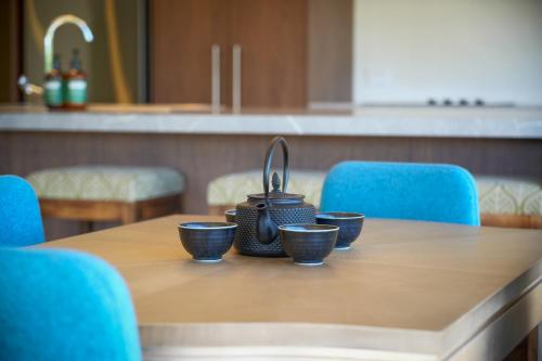 a table with a tea kettle and four cups on it at Parehua Resort in Martinborough 