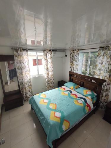 Un dormitorio con una cama con un edredón azul. en Apartamentos Familiares The Upper room 202, en San Andrés