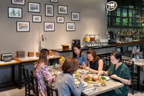a group of women sitting at a table eating food at Hotel Traveltine in Singapore