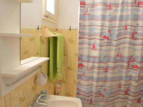 une salle de bain avec un rideau de douche et un lavabo dans l'établissement Studio cabine avec terrasse et parking, à 250 m de la plage d'Aiguebelle, Le Lavandou - FR-1-251-187, au Lavandou