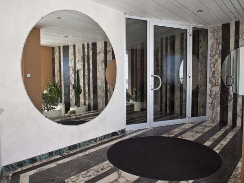 un couloir avec un miroir rond sur un mur dans l'établissement Appartement avec accès direct à la plage, balcon et garage privé - FR-1-92-690, à Les Sables-dʼOlonne