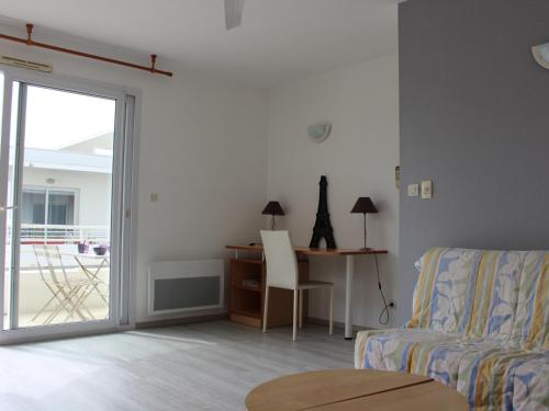 un salon avec un canapé et un bureau dans l'établissement Appartement T2 avec balcon, parking et piscine, proche commodités - FR-1-535-32, à La Rochelle