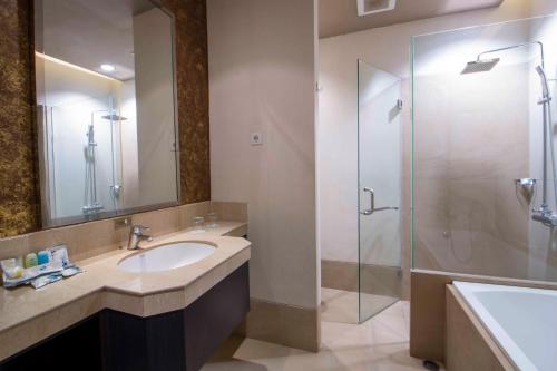 a bathroom with a sink and a glass shower at Solaris Hotel Malang in Malang