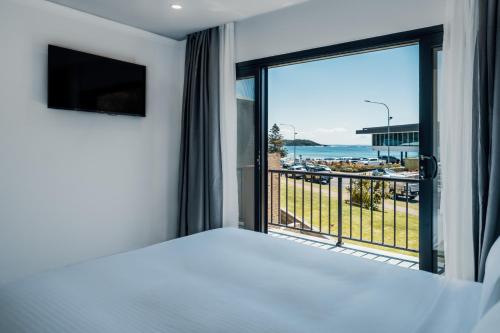 a bedroom with a large window with a view of the ocean at Mollymook Shores in Mollymook