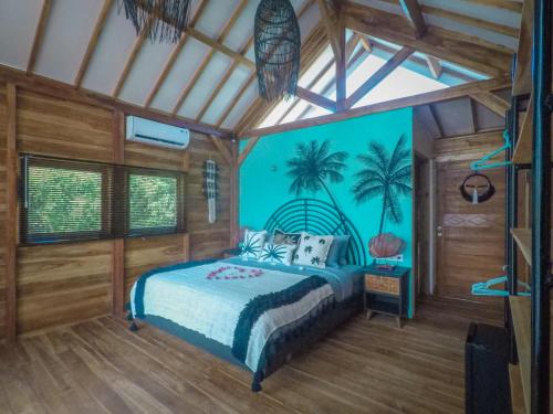 a bedroom with a bed with palm trees painted on the wall at Rumah Tara Gili Air Rooftop Bungalow with Terrace and Whirlpool in Gili Air