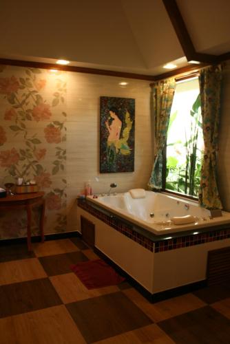 a large bathroom with a tub and a window at Villa Angelica Bed and Breakfast in Phuket in Bang Tao Beach