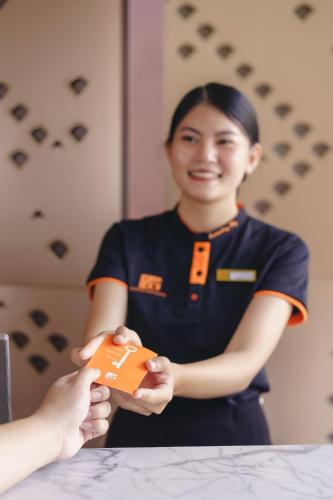a woman is holding a small object in her hand at Fifth Pattaya Jomtien By Shiwalai Int in Jomtien Beach