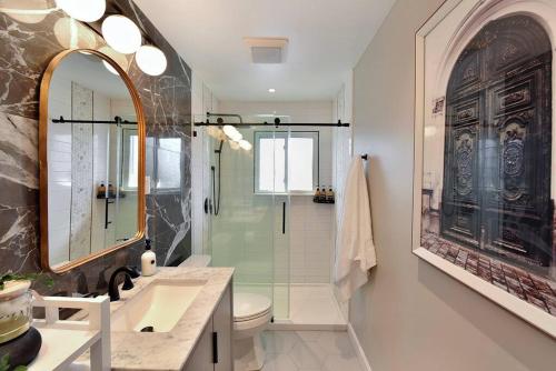 a bathroom with a shower and a sink and a mirror at The Creative Experience 3 bedroom Residential Home in West Hempstead