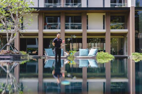 a man in a suit standing in front of a building at Fifth Pattaya Jomtien By Shiwalai Int in Jomtien Beach