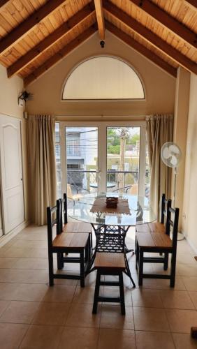 een eetkamer met tafels en stoelen en een groot raam bij Los Balcones Madryn in Puerto Madryn