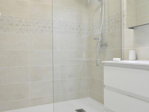 une douche avec une porte vitrée dans une salle de bain dans l'établissement Appartement rénové 2021 avec balcon et garage, proche golf, 3 pièces, 6 couchages, Le Lavandou. - FR-1-251-425, au Lavandou