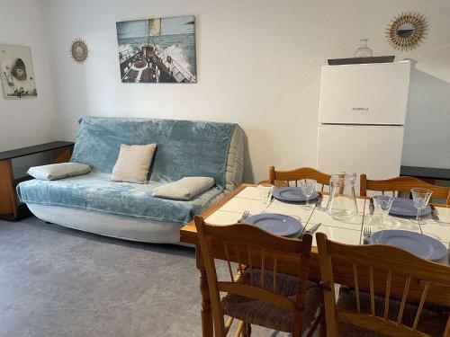 un salon avec une table et un canapé dans l'établissement Appartement T2 avec Cabine, 4 Couchages, Proche Plage - Saint-Hilaire-de-Riez - FR-1-224-795, à Saint-Hilaire-de-Riez