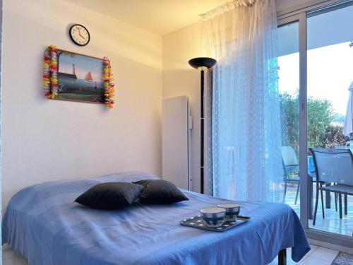 - une chambre avec un lit et un plateau de nourriture dans l'établissement Appartement familial climatisé avec piscine, terrasse et parking - 5 couchages - Le Lavandou - FR-1-251-426, au Lavandou