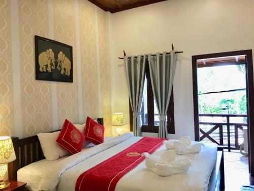 Un dormitorio con una cama con dos cuencos. en Luang Prabang Pangkham Lodge en Luang Prabang
