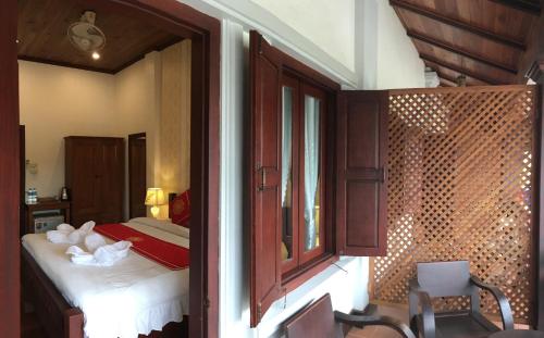 a bedroom with a bed and a window in a room at Luang Prabang Pangkham Lodge in Luang Prabang