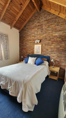 a bedroom with a large bed with a brick wall at Los Balcones Madryn in Puerto Madryn