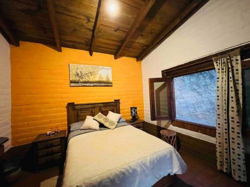 a bedroom with a bed and a window at Cabaña en Malinalco El rincón de Anita in Malinalco