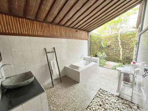 y baño con bañera, lavabo y aseo. en Intan Villa & Suite Ubud, en Ubud